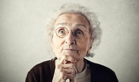 Online-Ratgeber Demenz (Bildquelle: Plegever/Shutterstock) Foto: Eine Seniorin mit weißem Haar und Brille schaut nachdenklich nach oben, den Kopf auf ihre Hand gestützt