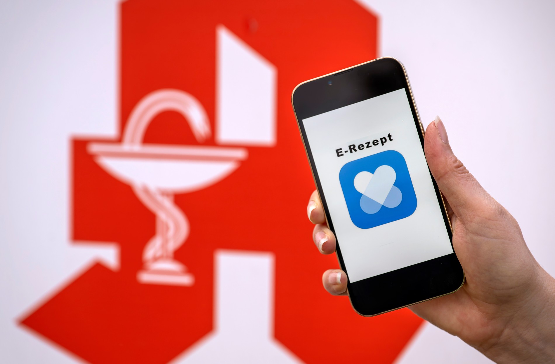 Symbolbild zum E-Rezept - Smartphone vor dem rote Apotheken-A