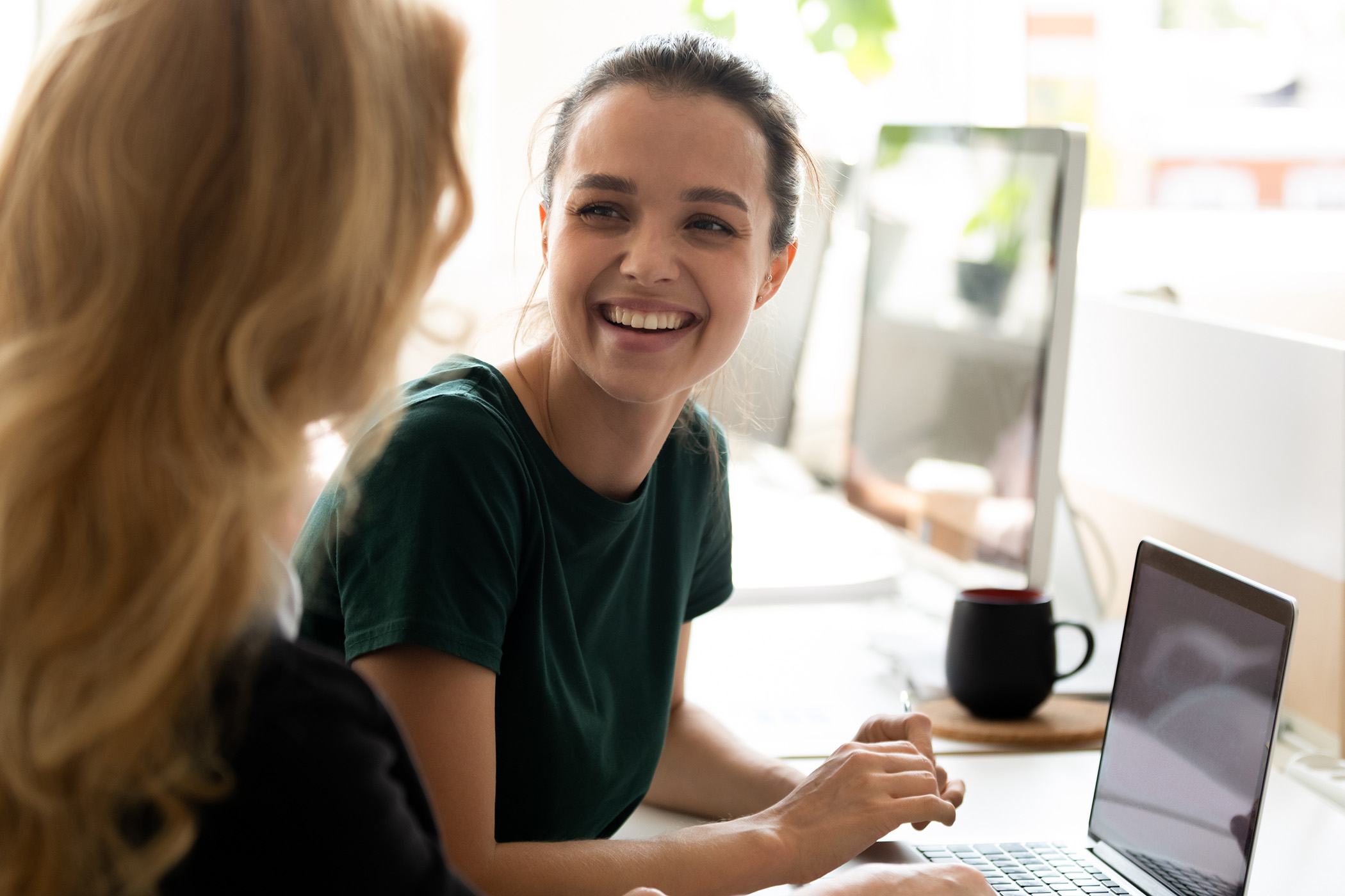Junge Frauen am Arbeitsplatz im Gespräch