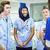 Foto: Pflegepersonal im Krankenhaus mit fünf Personen, teiweise mit Kopftuch, verschiedener Hautfarbe, männglich und weiblich