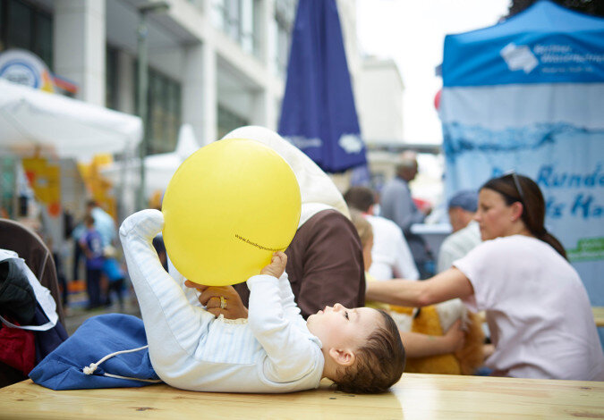 Foto: Ein Kleinkind im Strampelanzug liegt auf einem Tisch und balanciert