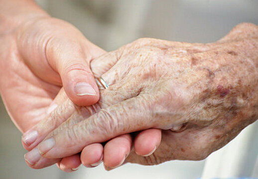 Foto: Die Hand einer jungen Frau greift die Hand einer alten Frau 