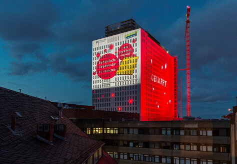 Foto: Projektion der symbolischen Masernpunkte auf das Bettenhochhaus der Universitätsklinik Charité