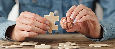 Ein Psychologe hält das menschliche Gehirn und das Rätsel. Problemlösung, Hilfe. Konsultation und Behandlung von Nervenkrankheiten.