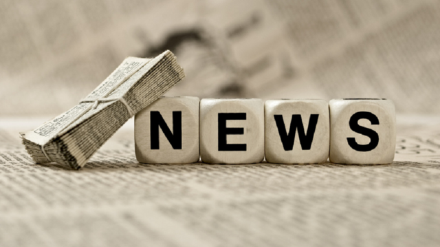 Photo: Dices spelling the word "news", lying on a newspaper