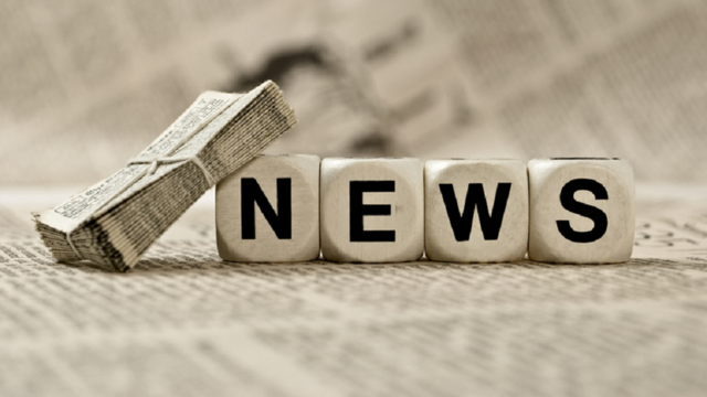 Photo: Dices spelling the word "news", lying on a newspaper