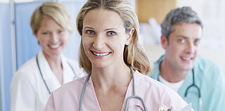 Drei lächelnde Ärzte: Attraktive Arbeitsbedingungen schaffen die Grundlage für berufliche Zufriedenheit professionell Pflegender und eine gute Versorgung Pflegebedürftiger