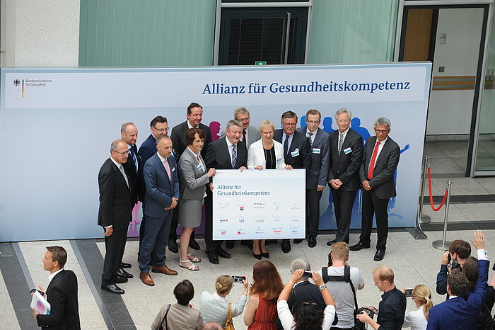 Gruppenfoto mit Bundesgesundheitsminister Hermann Gröhe mit den Partnern der Allianz für Gesundheitskompetenz, im Vordergrund Fotografen
