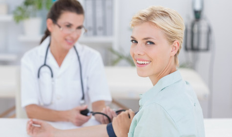 Ärztin und Patientin (Bildquelle: wavebreakmedia/Shutterstock.com) Foto: Eine Ärztin misst den Blutdruck einer jungen Frau.