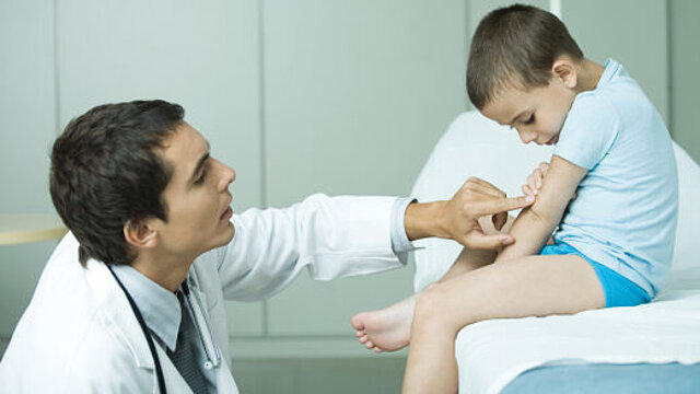Foto: Ein Arzt untersucht einen Jungen 