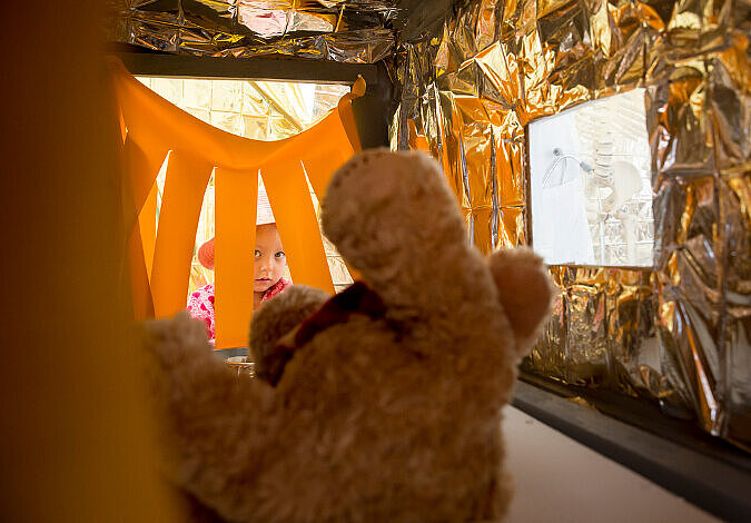 Ein Mädchen lässt ihren Teddy in der Teddy-Klinik röntgen