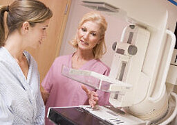 Foto: Eine Ärztin zeigt einer Patientin das Mammografie-Gerät