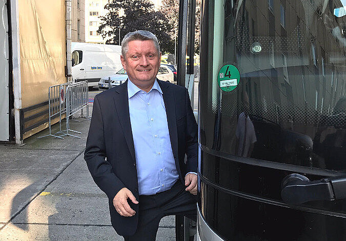 Foto: Hermann Gröhe steigt in den Reisebus und lächelt in die Kamera