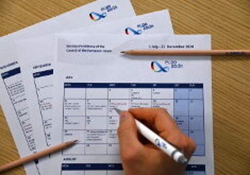 Eine Hand schreibt mit einem Kugelschreiber in den Kalender der EU-Ratspräsidentschaft