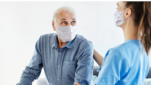 Patient und Pflegerin mit Maske