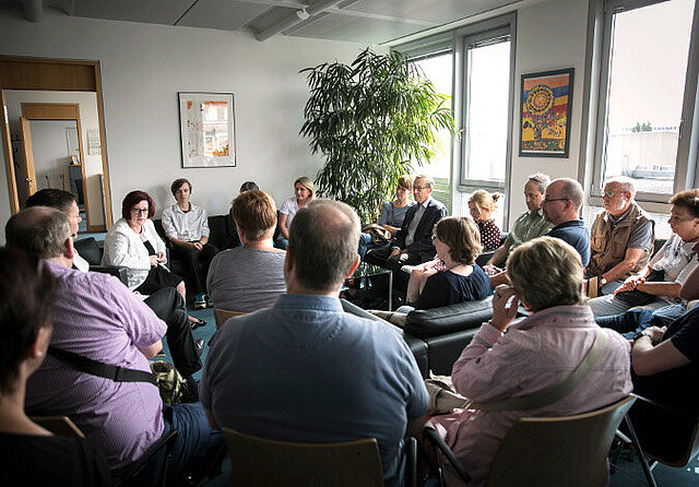 Foto: Ingrid Fischbach und die Besucherinnen und Besucher sitzen in einem Büro-Raum