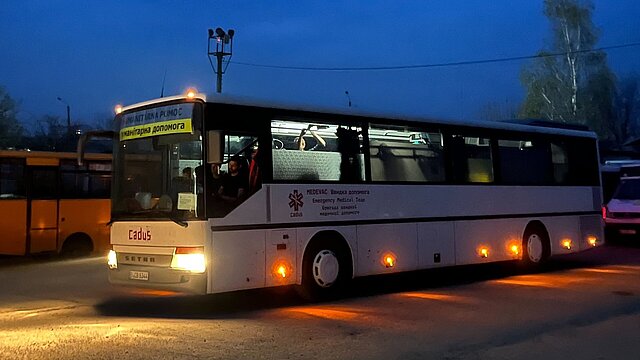Ukraine-Hilfe Rettungsbus steht auf der Straße im Dunkeln - Licht an
