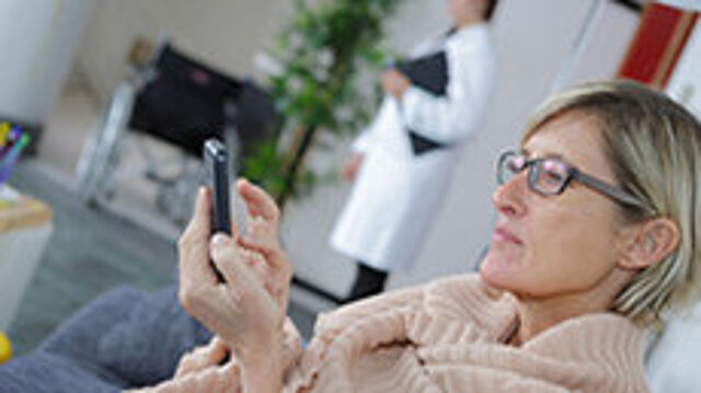 Testung digitaler Versorgungsangebote: Patientin mit einem Smartphone in einer Praxis
