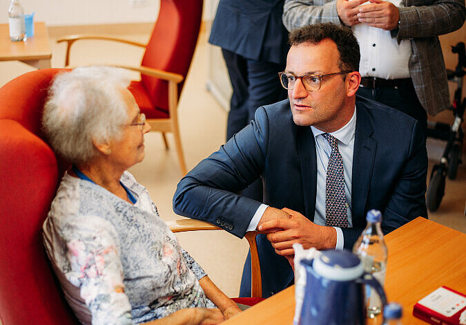 Bundesgesundheitsminister Jens Spahn im Gespräch mit einer älteren Frau
