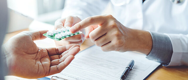 Arzt übergibt Tabletten an Patienten - Entwicklung eines KI-basierten Entscheidungsunterstützungssystems zur individualisierten Vorhersage wirksamer Antibiotikatherapien