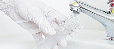 Labor-Glas wird unter Wasserhahn gefüllt
