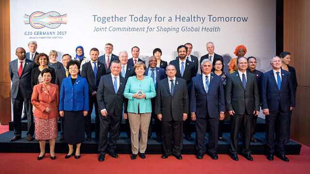 Gruppenbild mit Kanzlerin und allen Gesundheitsministerinnen und Ministern der G20 [Bildquelle: BMG/Inga Kjer (photothek)]