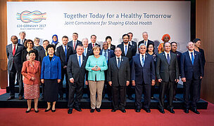 Gruppenbild mit Kanzlerin und allen Gesundheitsministerinnen und Ministern der G20 [Bildquelle: BMG/Inga Kjer (photothek)]