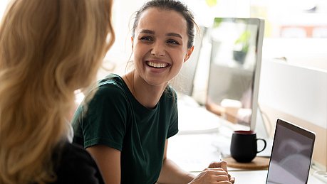 Junge Frauen am Arbeitsplatz im Gespräch