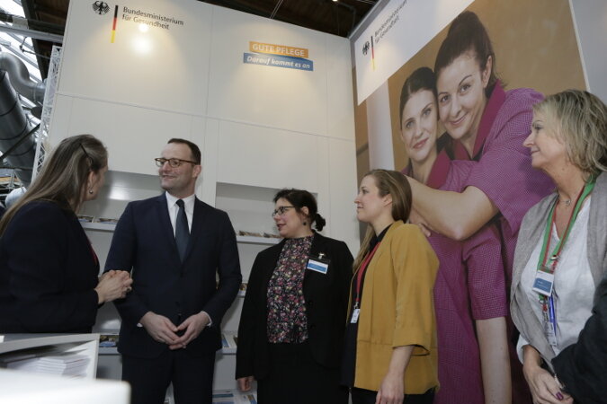 Jens Spahn spricht mit Mitarbeitern des Bundesgesundheitsministeriums am Informationsstand auf dem Deutschen Pflegetag