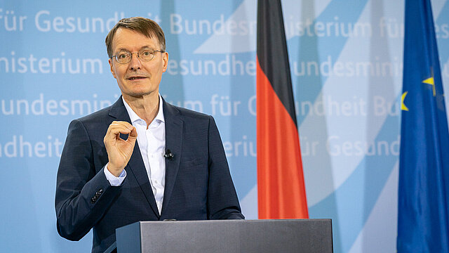 Foto: Bundesminister Karl Lauterbach am Rednerpult, im Hintergrund Deutschlandflagge und Flagge der Europäischen Union