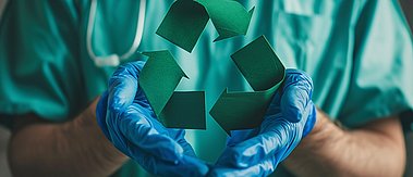Hände eines Arztes halten das Symbol für Recycling