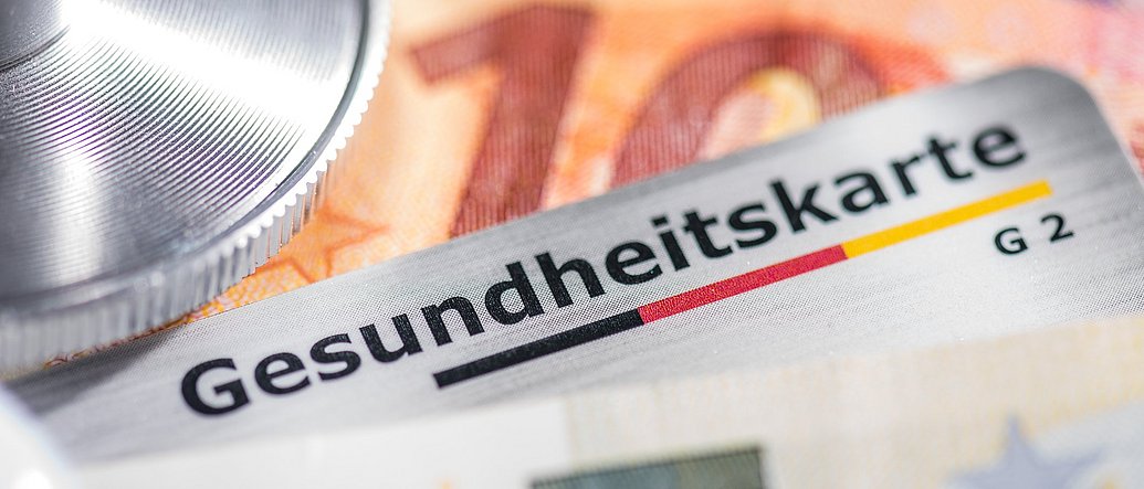 Gesundheitskarte mit Banknoten und Stethoskop