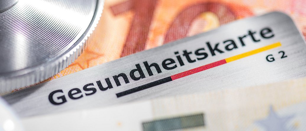 Gesundheitskarte mit Banknoten und Stethoskop