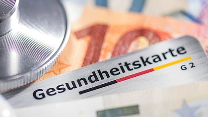 Gesundheitskarte mit Banknoten und Stethoskop