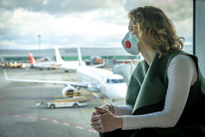 Frau mit Maske am Flughafen