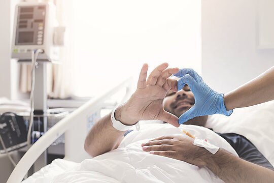 Patient und Arzt formen die Hände zu einem Herz