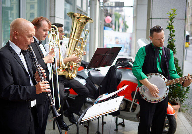 Foto: Eine Band spielt vor dem Eingang des Ministeriums auf Blechblasinstrumenten