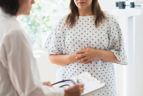 Frau im Krankenhauskittel im Gespräch mit der Ärztin