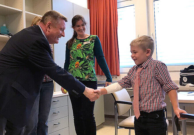 Foto: Bundesgesundheitsminister Gröhe gibt einem jungen Patienten die Hand