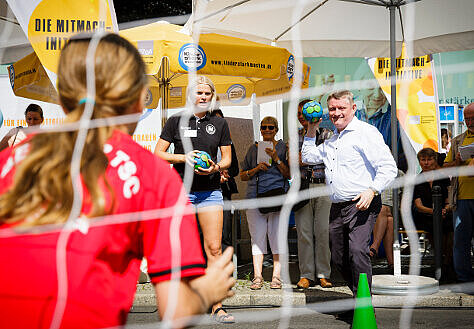 Minister Gröhe zielt auf ein Handballtor.