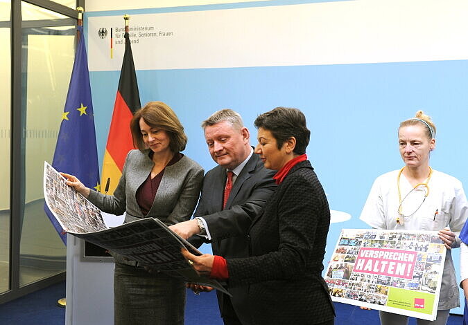Gröhe und Barley sehen sich die Fotobotschaft an