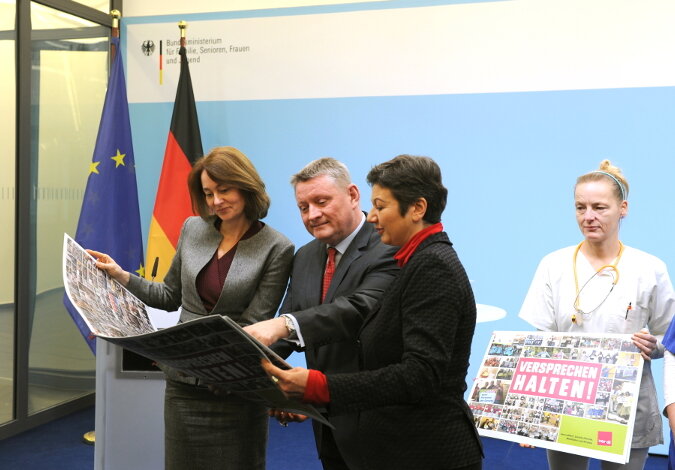 Gröhe und Barley sehen sich die Fotobotschaft an