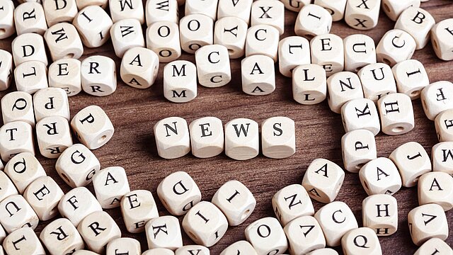 Foto: zahlreiche Würfel mit aufgedruckten Buchstaben, im Zentrum das zusammengesetzte Wort: News
