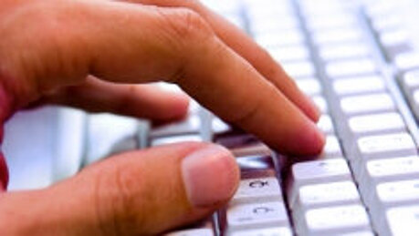 Foto: Eine Hand liegt auf einer Computer-Tastatur