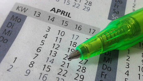 Foto: Ein grüner Stift liegt auf einem Kalender 