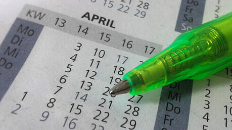 Foto: Ein grüner Stift liegt auf einem Kalender 