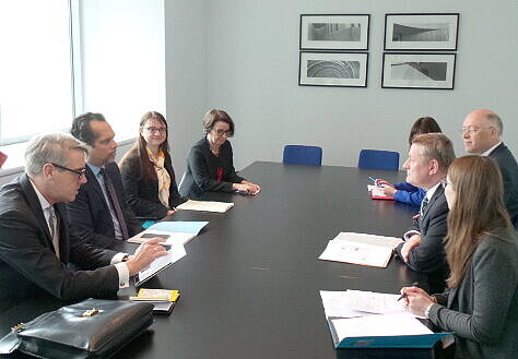 Foto: Ramesh Rajasingham, Direktor des "High Level Panel on the Global Response to Health Crises", und Minister Gröhe sitzen sich an einem Tisch gegenüber und tauschen sich aus; weitere Teilnehmende des Treffens sitzen ebenfalls am Tisch