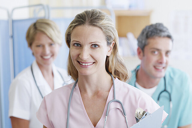 Drei lächelnde Ärzte: Attraktive Arbeitsbedingungen schaffen die Grundlage für berufliche Zufriedenheit professionell Pflegender und eine gute Versorgung Pflegebedürftiger.