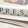 Foto: Das Wort Presse liegt in Würfeln auf einer Zeitung 