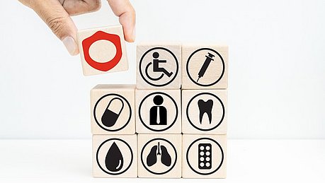 Holzwürfel mit aufgedruckten Symbolen aus dem Gesundheits- und Medizinbereich